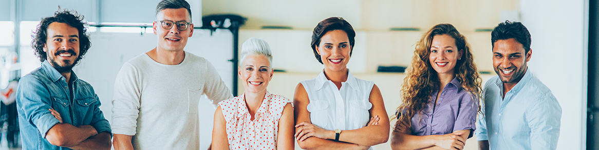 Diverse group of adults smiling in a sunny workplace environment