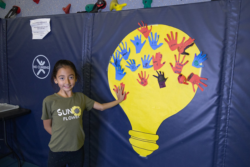 Student stands in front of a bulletin board during a Lights On Afterschool event in Thronton.