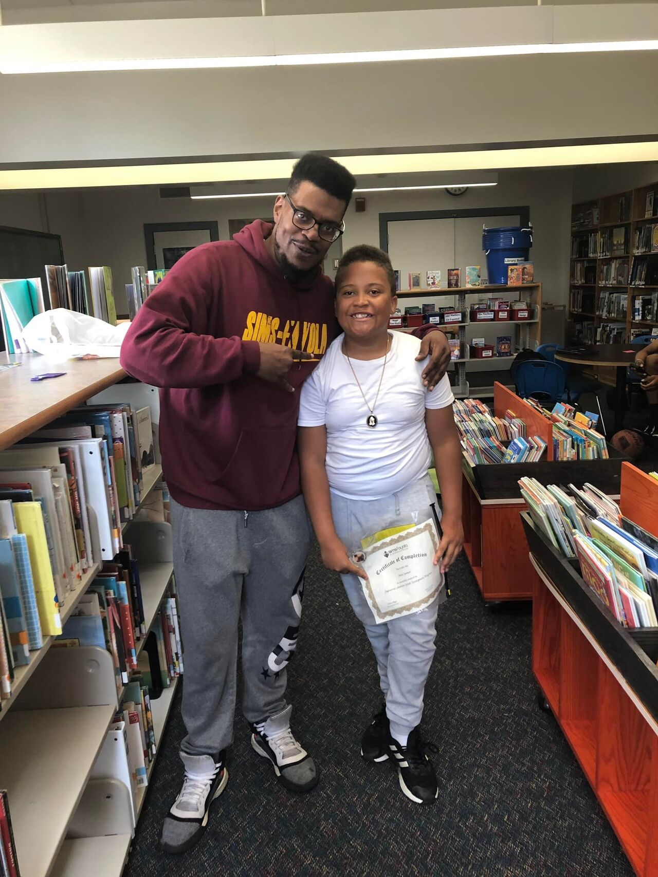 From 2022, a Stedman Elementary School student celebrates the end of an 18-week EAYD program with Coach Josh Mayes. 