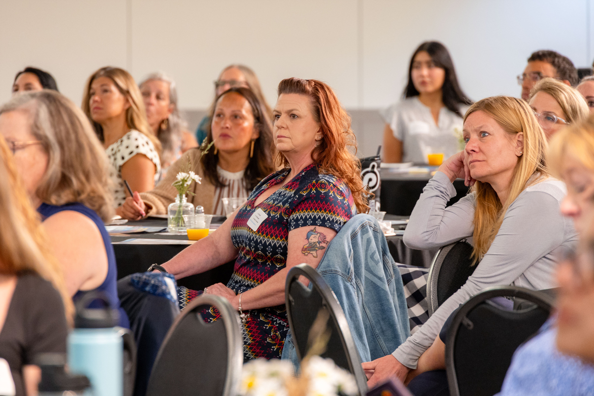 A woman in the audience listens. 