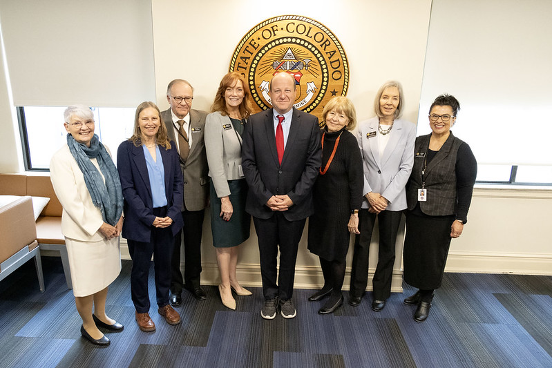 Gov. Jared Polis stands with members of the Colorado State Board of Education