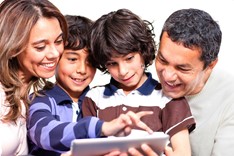 A family smiling and reading a book together